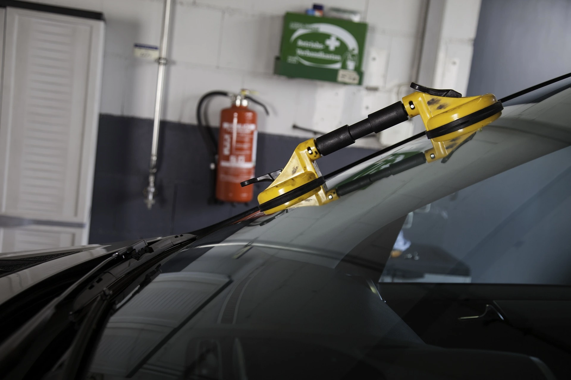 The interior of an auto glass shop where a windshield is being replaced.